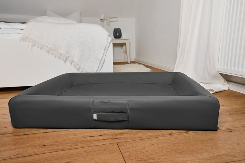 Produktbild für das "AMMI Bed" im AMMI for Dogs Onlineshop. Ein gemütliches orthopädisches Hundebett im Schlafzimmer auf dem Boden.