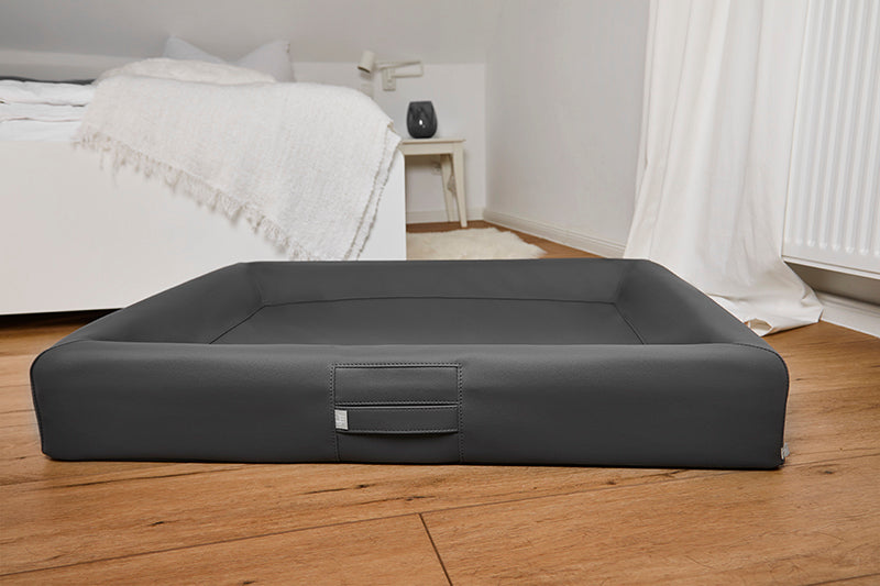 Produktbild für das "AMMI Bed" im AMMI for Dogs Onlineshop. Ein gemütliches orthopädisches Hundebett im Schlafzimmer auf dem Boden.